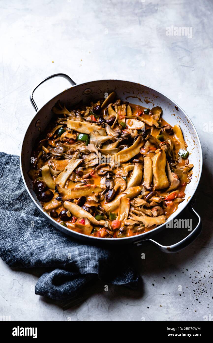 Funghi e peperoni affettati saltati in padella. Foto Stock
