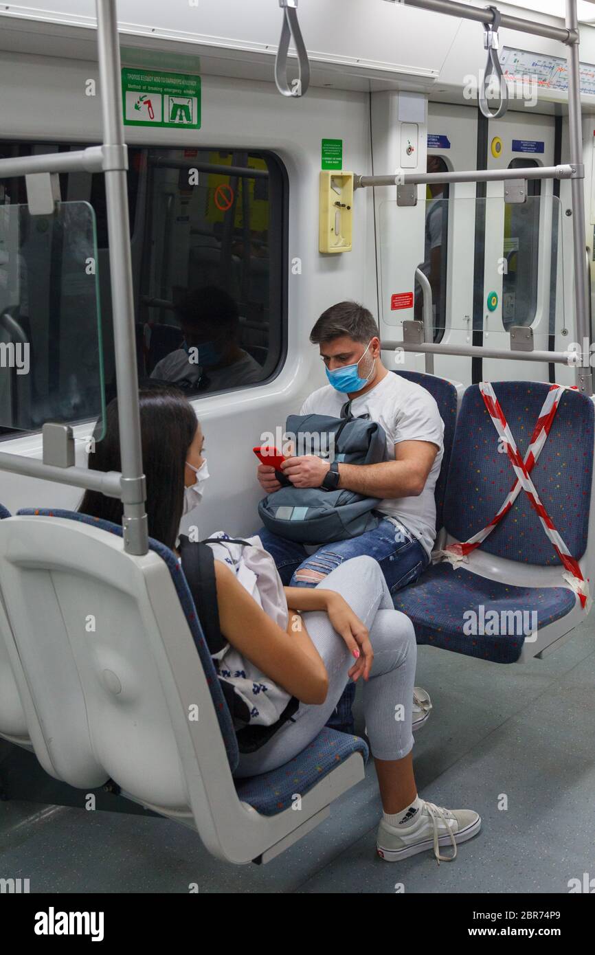 I passeggeri della metropolitana di Atene indossano maschere protettive e utilizzano metà dei sedili come indicato dal governo greco a causa dell'epidemia di coronavirus Foto Stock