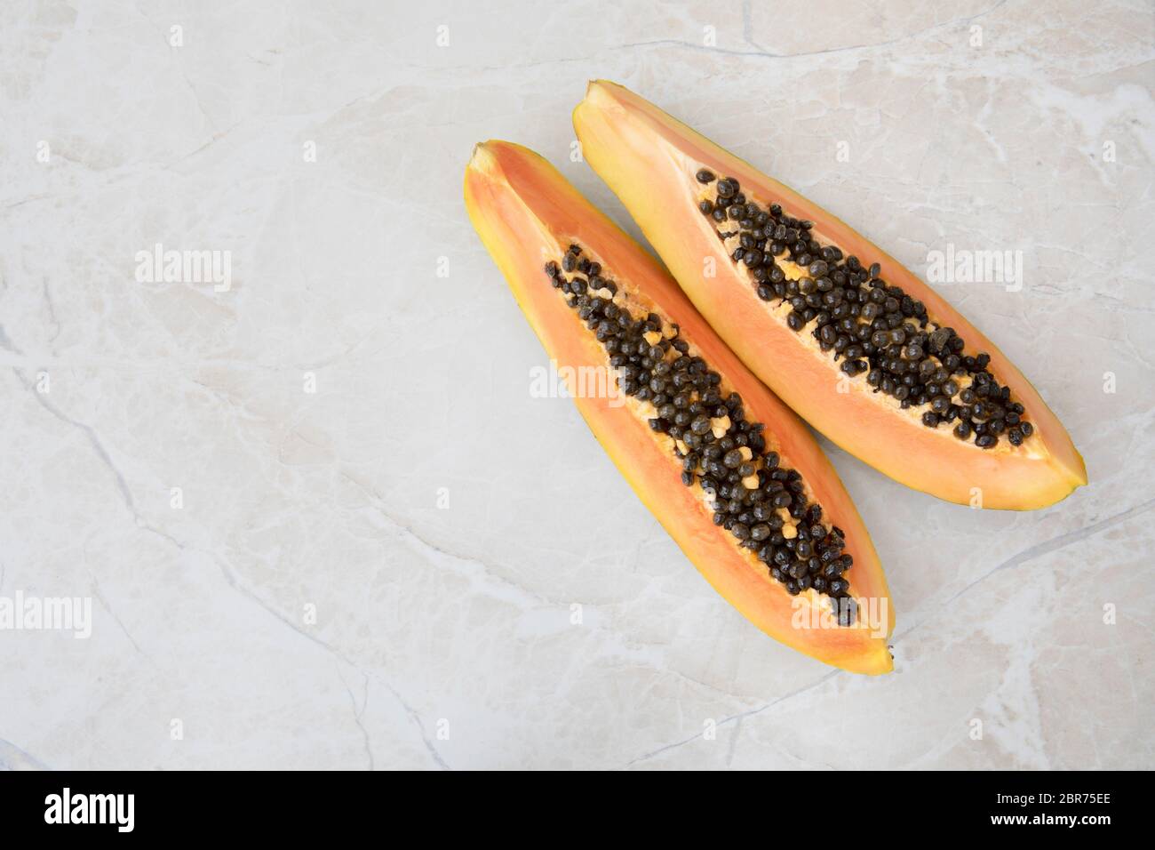 Trimestre fette di papaya su un piano di marmo con copia spazio. Foto Stock