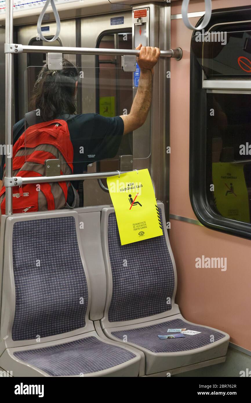 "Non sono seduto qui" dire la rcard su metà dei posti in vagoni della metropolitana di Atene, che istruisce i passeggeri a mantenere le distanze dovute all'epidemia di coronavirus Foto Stock