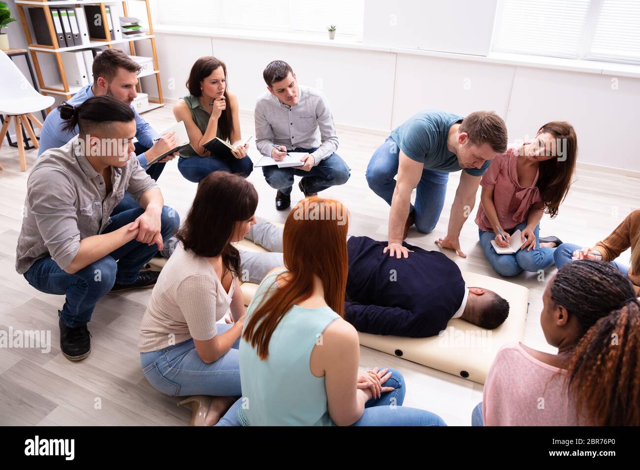 Specialista di sesso maschile di eseguire il massaggio sull'uomo durante il corso di formazione Foto Stock