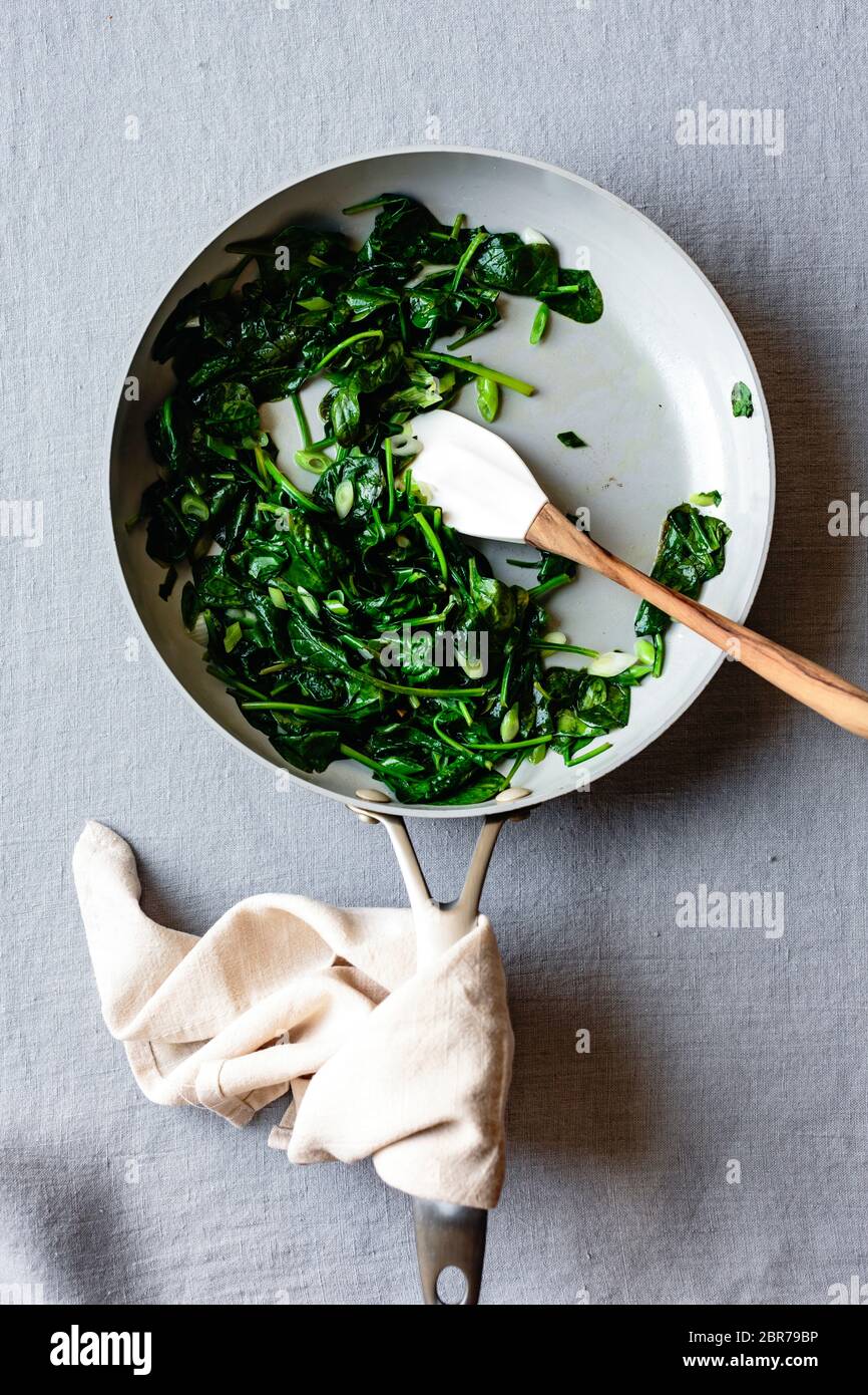 Spinaci e capesante saltati in una padella. Foto Stock