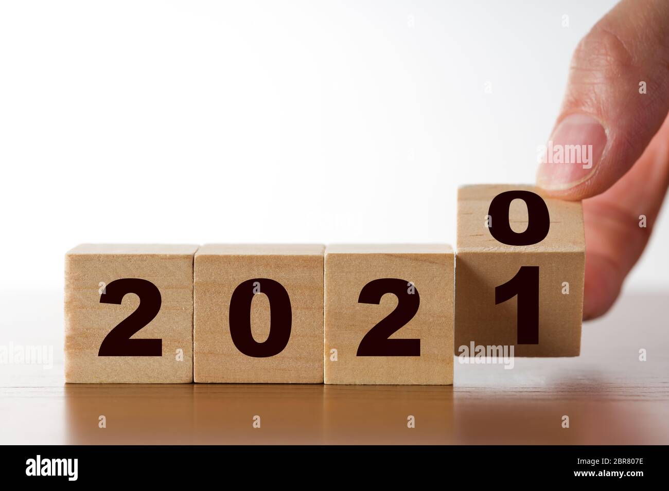 2021 figura su cubi di legno, a mano che capovolgono i cubi con anno 2020 a 2021. concetto di anno nuovo. Foto Stock