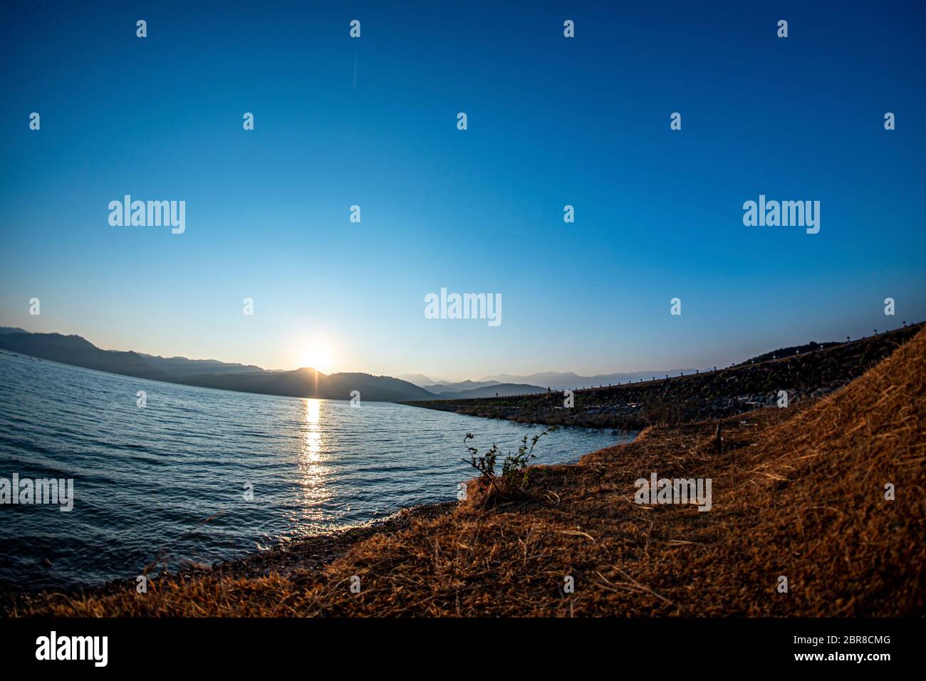 Alba al serbatoio, cielo azzurro chiaro, grandangolo da Lens Fisheye, 9 marzo 2019, Khlong DIN Daeng serbatoio, Nakhon si Thammarat, Thailandia Foto Stock