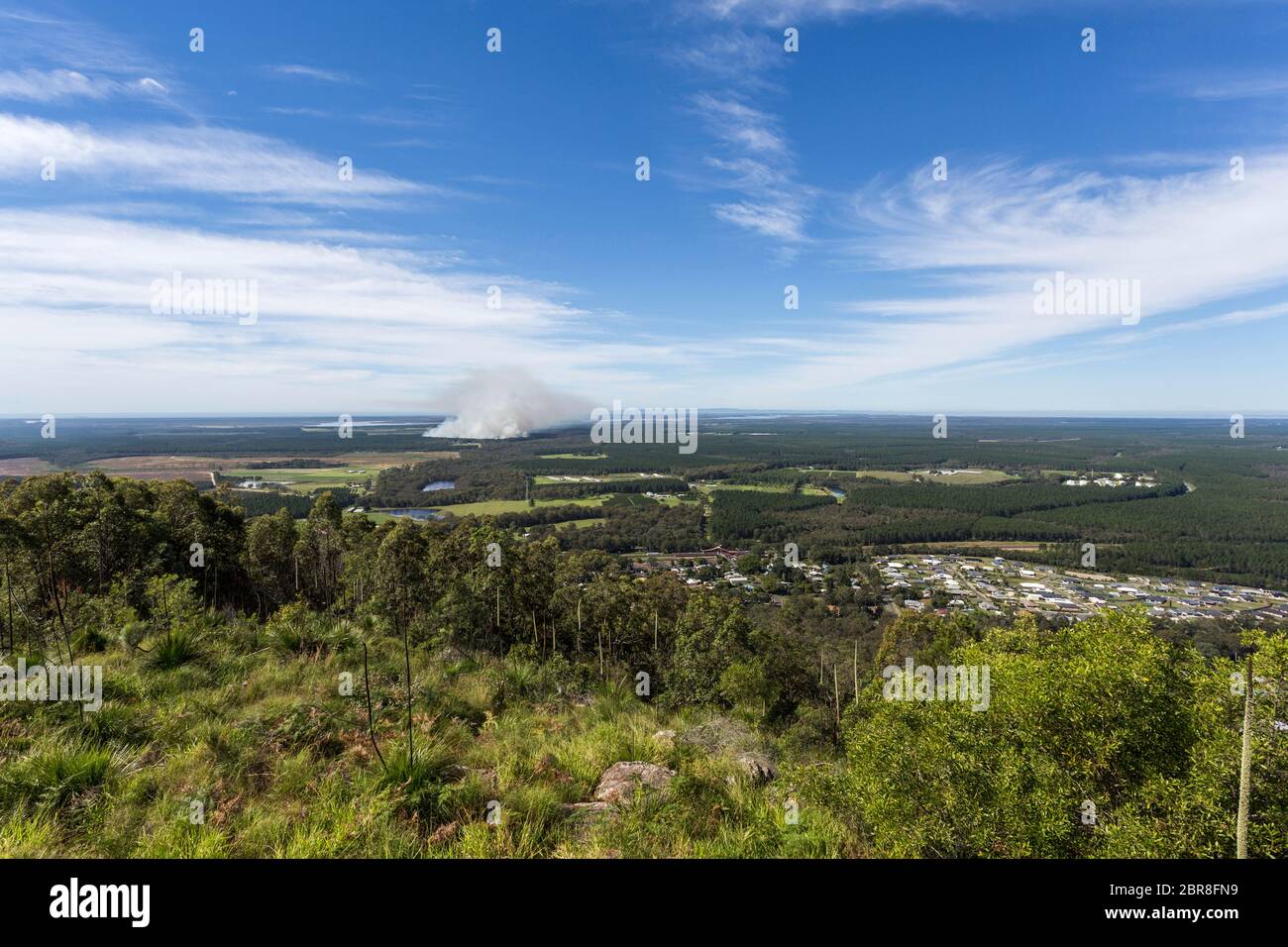 Vista Panoramica verso est della vetta del Monte Beerburrum, casa di vetro montagne, con un fuoco controllato a distanza. Foto Stock