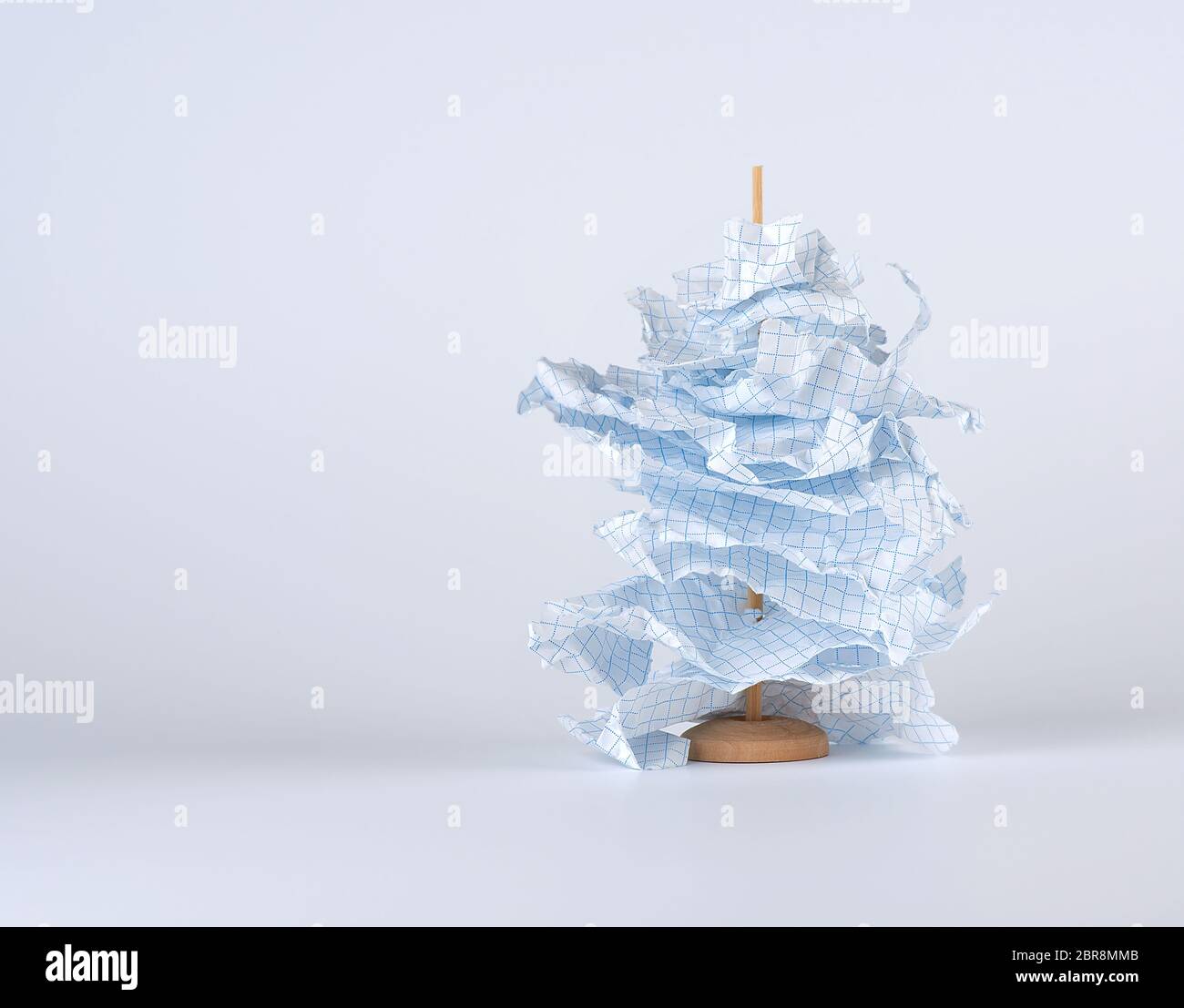 Pezzi strappati di white paper sono infilati su un bastone di legno, sfondo bianco spazio copia Foto Stock