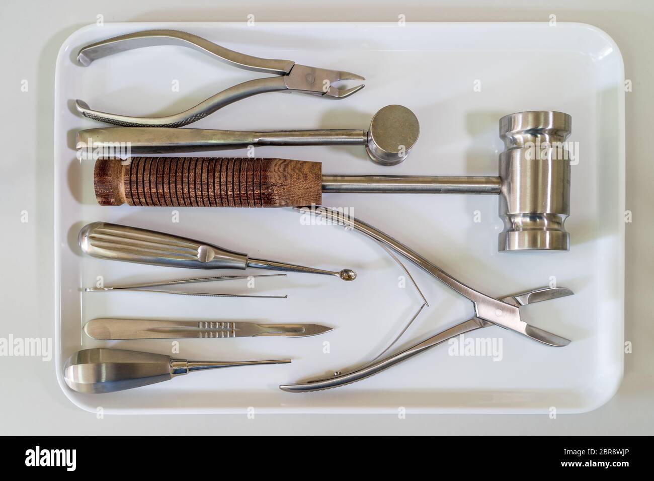 Gli strumenti chirurgici impostato o apparecchiature mediche sul vassoio bianco su bianco piano di lavoro di laboratorio Foto Stock