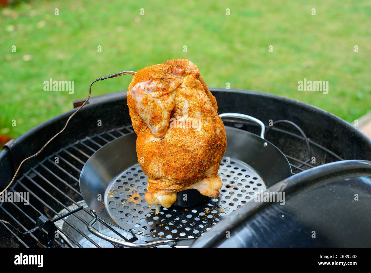 Una lattina di birra pollo in un barbecue pronto per il grill, con paprica e strofinare la sonda di temperatura Foto Stock