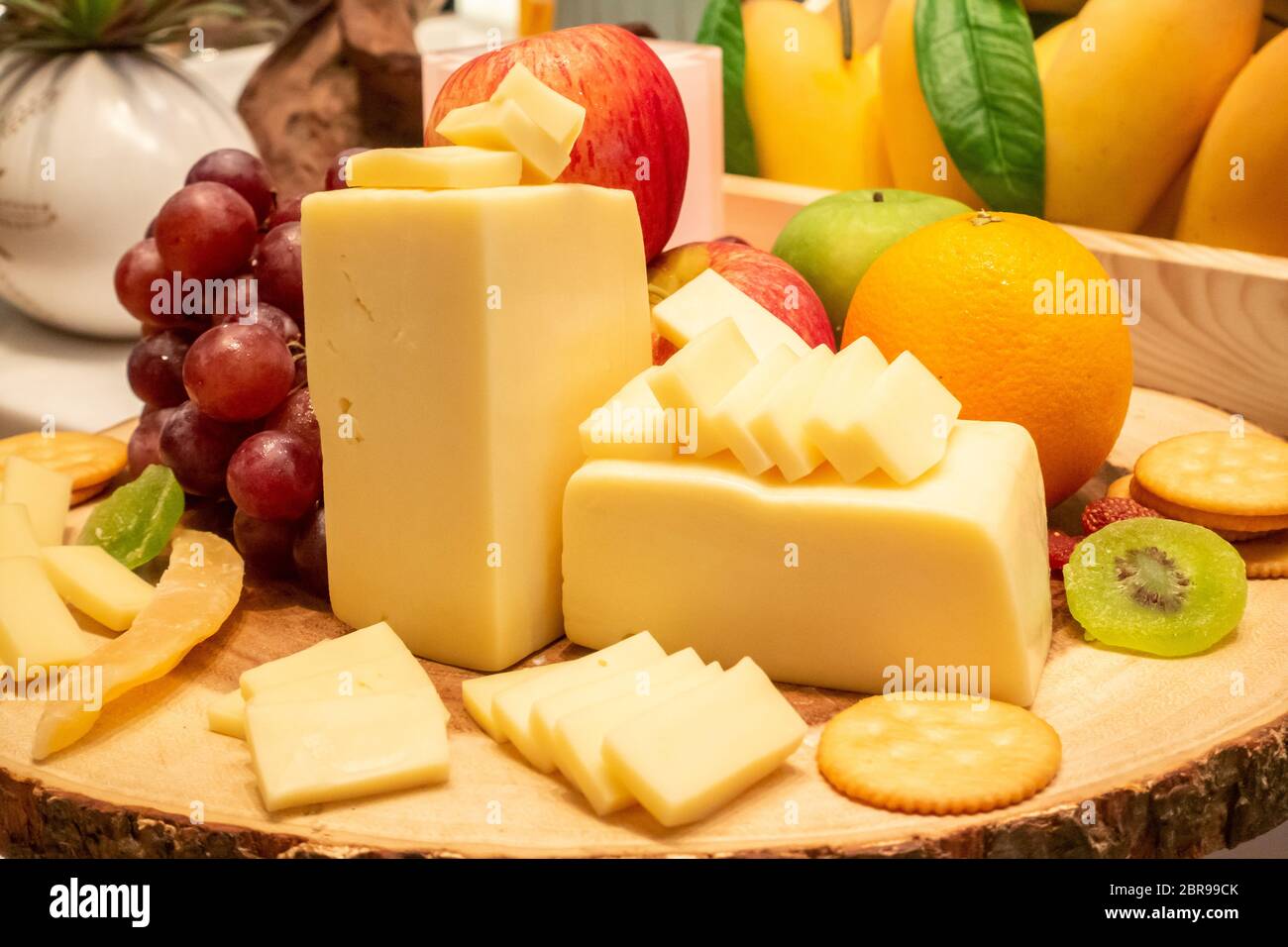 Il formaggio edam con varietà di frutta e cracker sul piatto di legno in linea a buffet Foto Stock