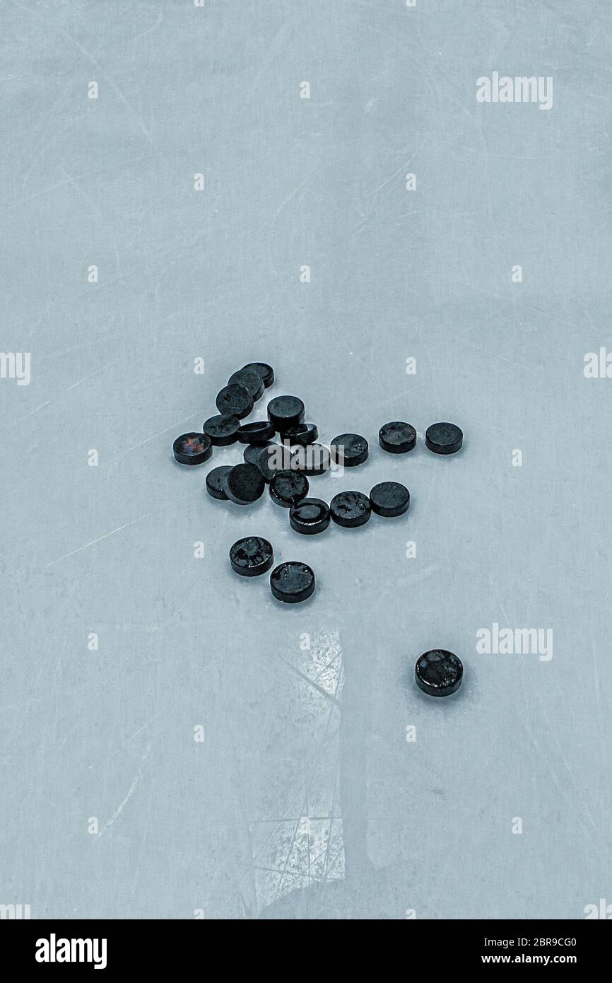 Fondo pista di hockey su ghiaccio, puck neri Foto Stock