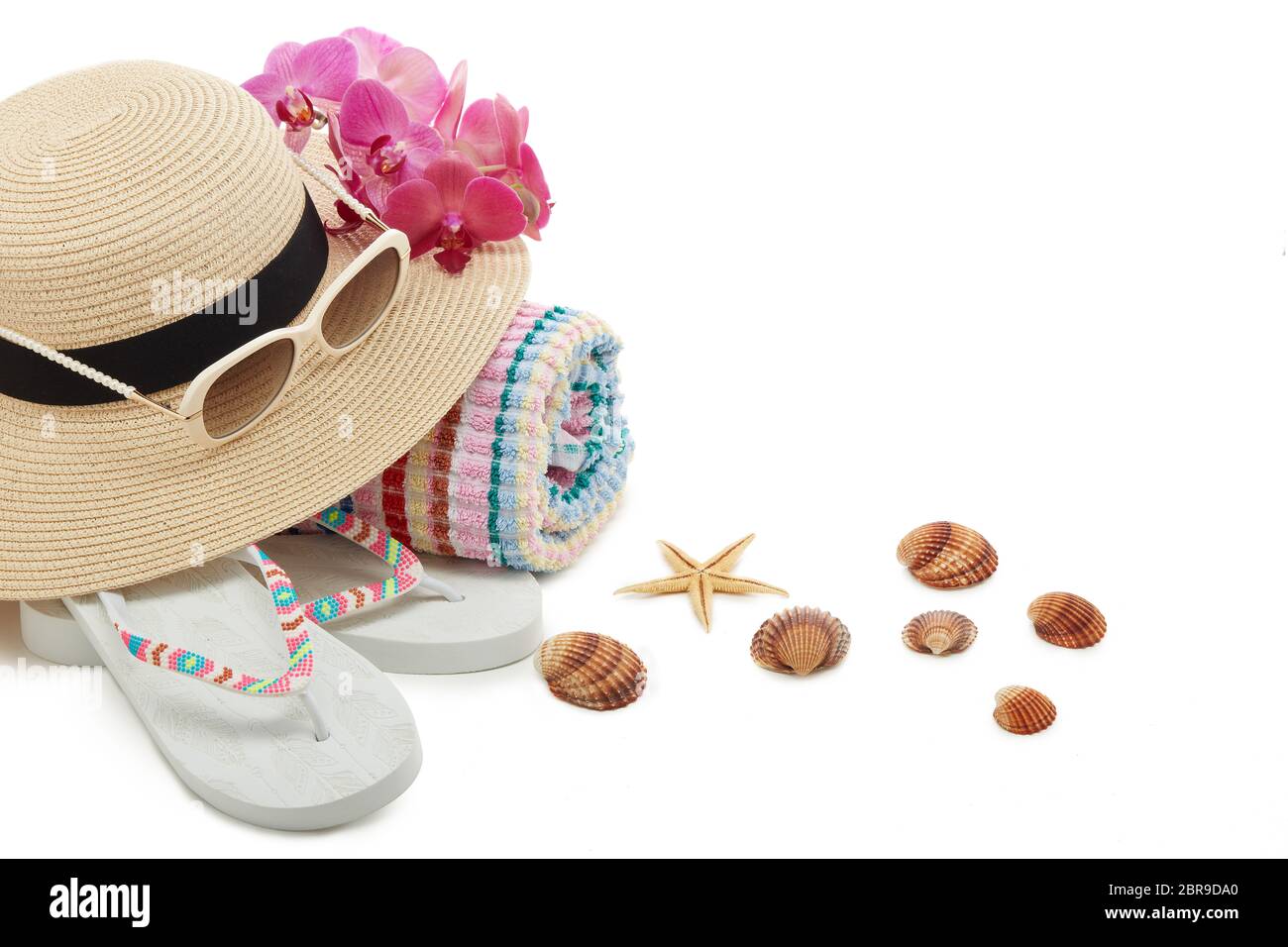 Accessori spiaggia: Infradito, cappello di paglia, occhiali da sole, asciugamano isolato su sfondo bianco con spazio per la copia. Concetto di vacanza e viaggio in mare. Estate b Foto Stock