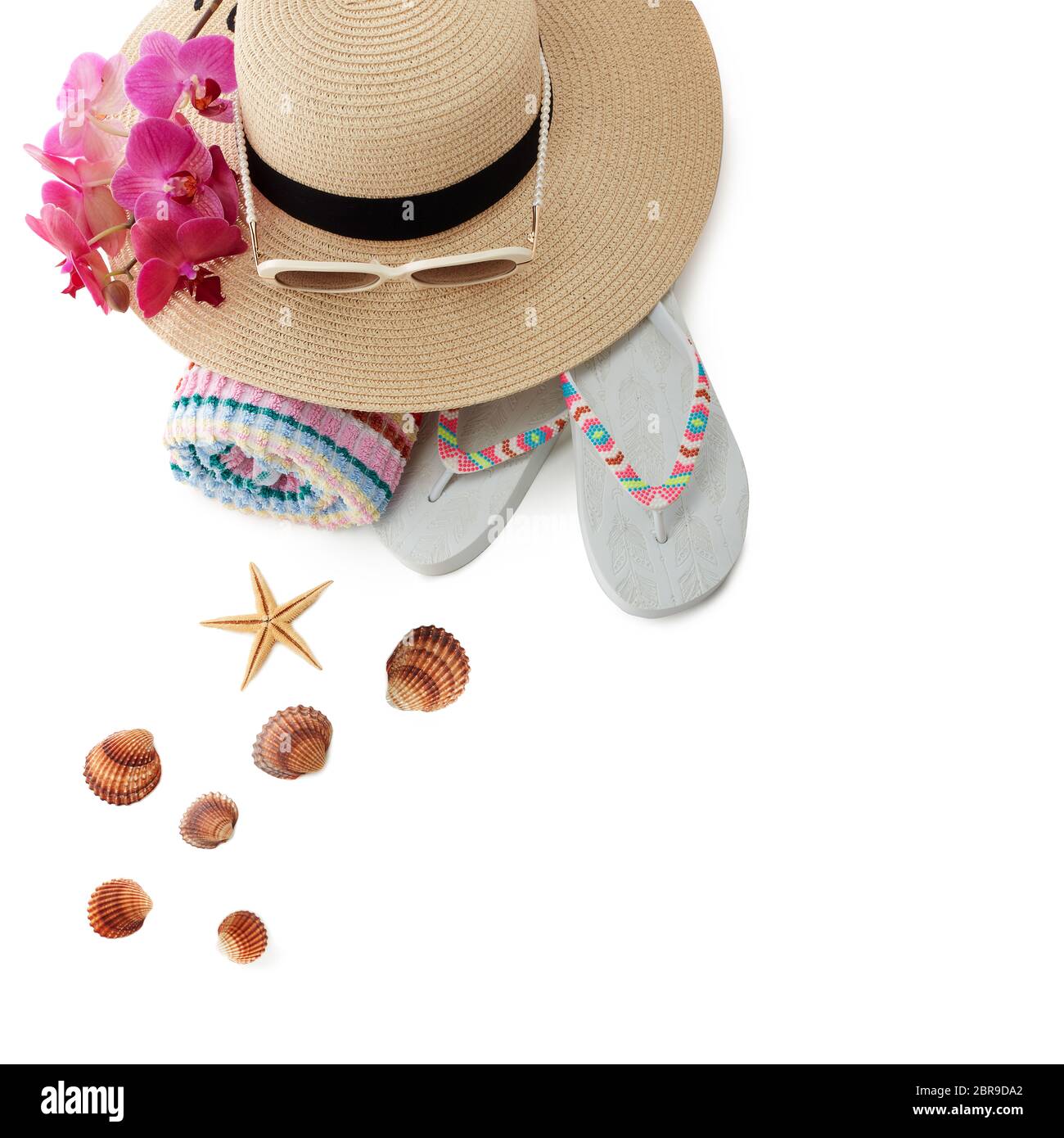 Accessori spiaggia: Infradito, cappello di paglia, occhiali da sole, asciugamano isolato su sfondo bianco. Vista dall'alto con spazio per la copia. Concetto di vacanza e viaggio in mare Foto Stock