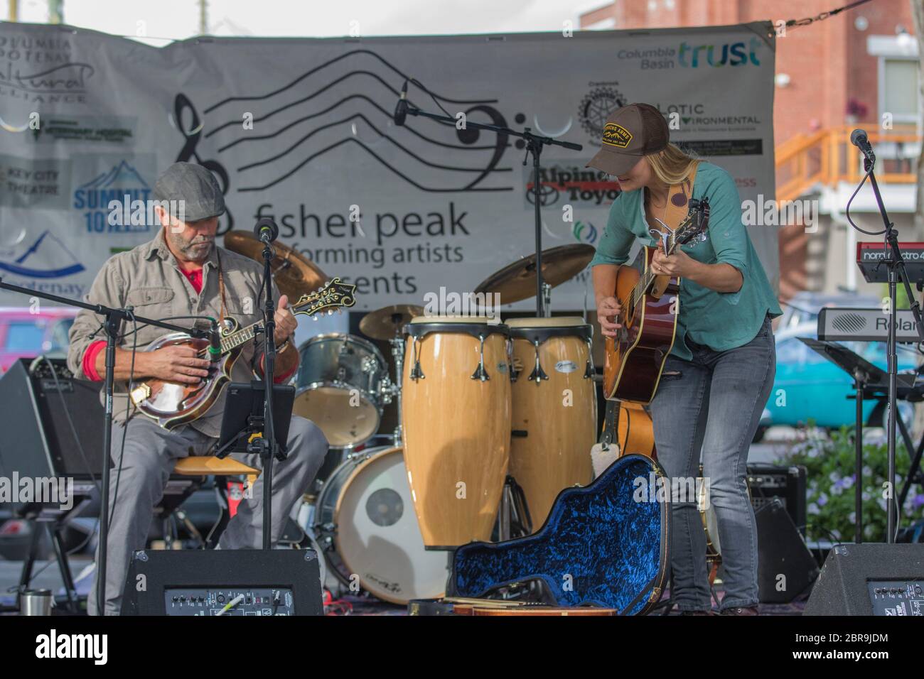 Duo maschile e femminile, che si esibisce all'aperto in concerto. Cantare e suonare chitarra e mandolino. Foto Stock