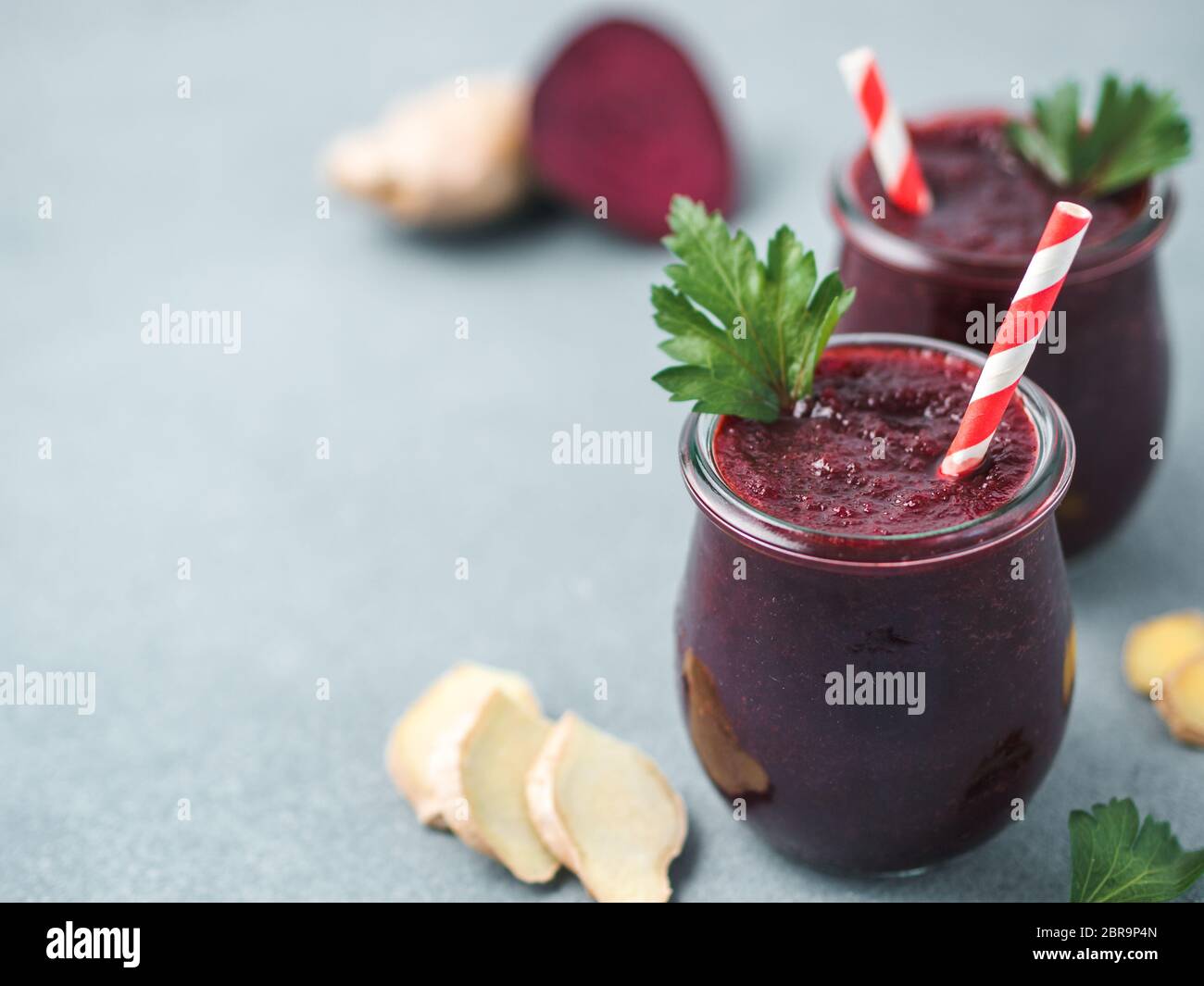 La barbabietola rossa fresca e radice di zenzero frullato. Frullato di barbabietole in un barattolo di vetro sulla tabella grigia. DOF poco profondo. Copia spazio per il testo. Pulire e mangiare concep detox Foto Stock