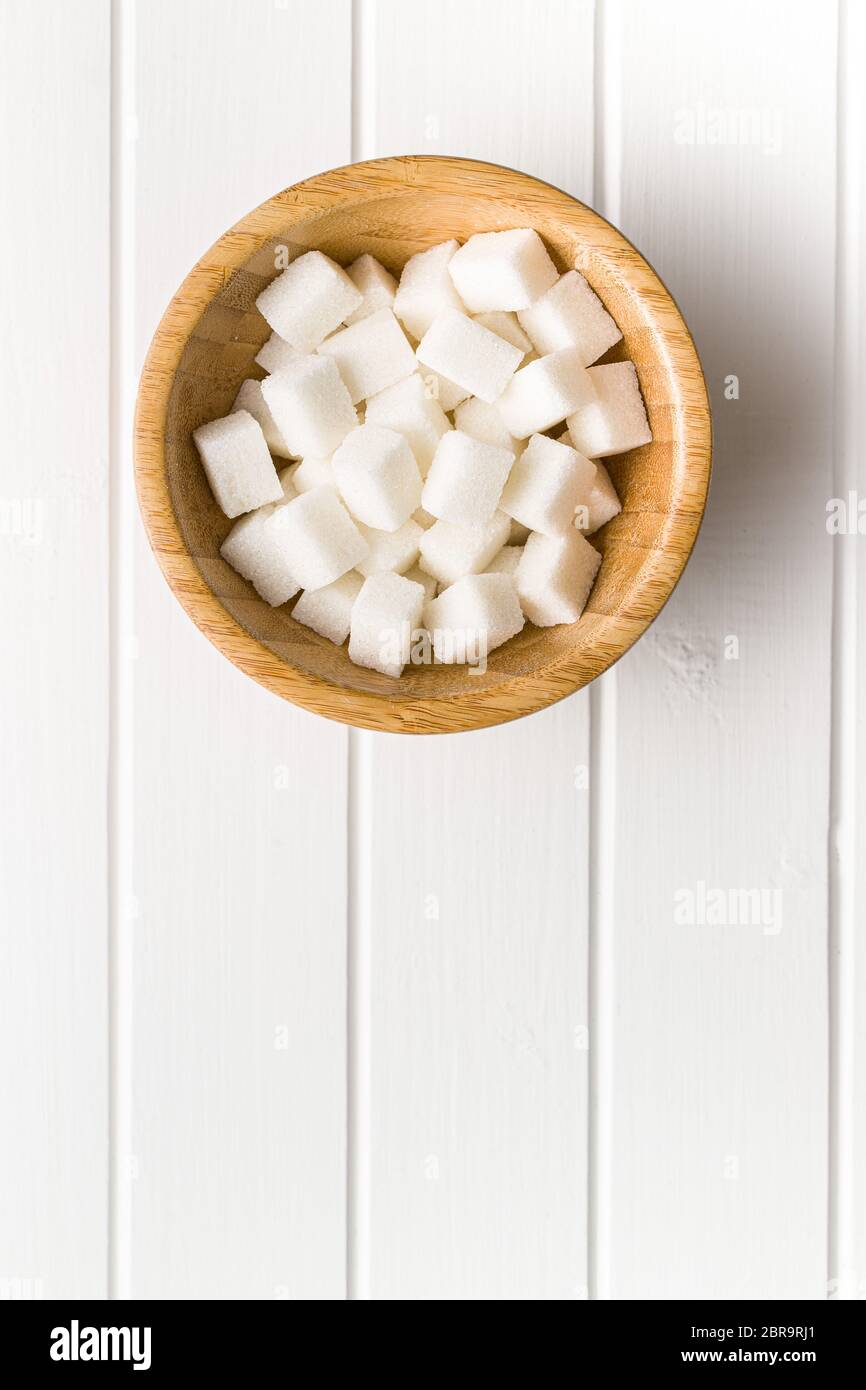 Bianco dolce cubetti di zucchero nella ciotola di legno. Vista dall'alto. Foto Stock