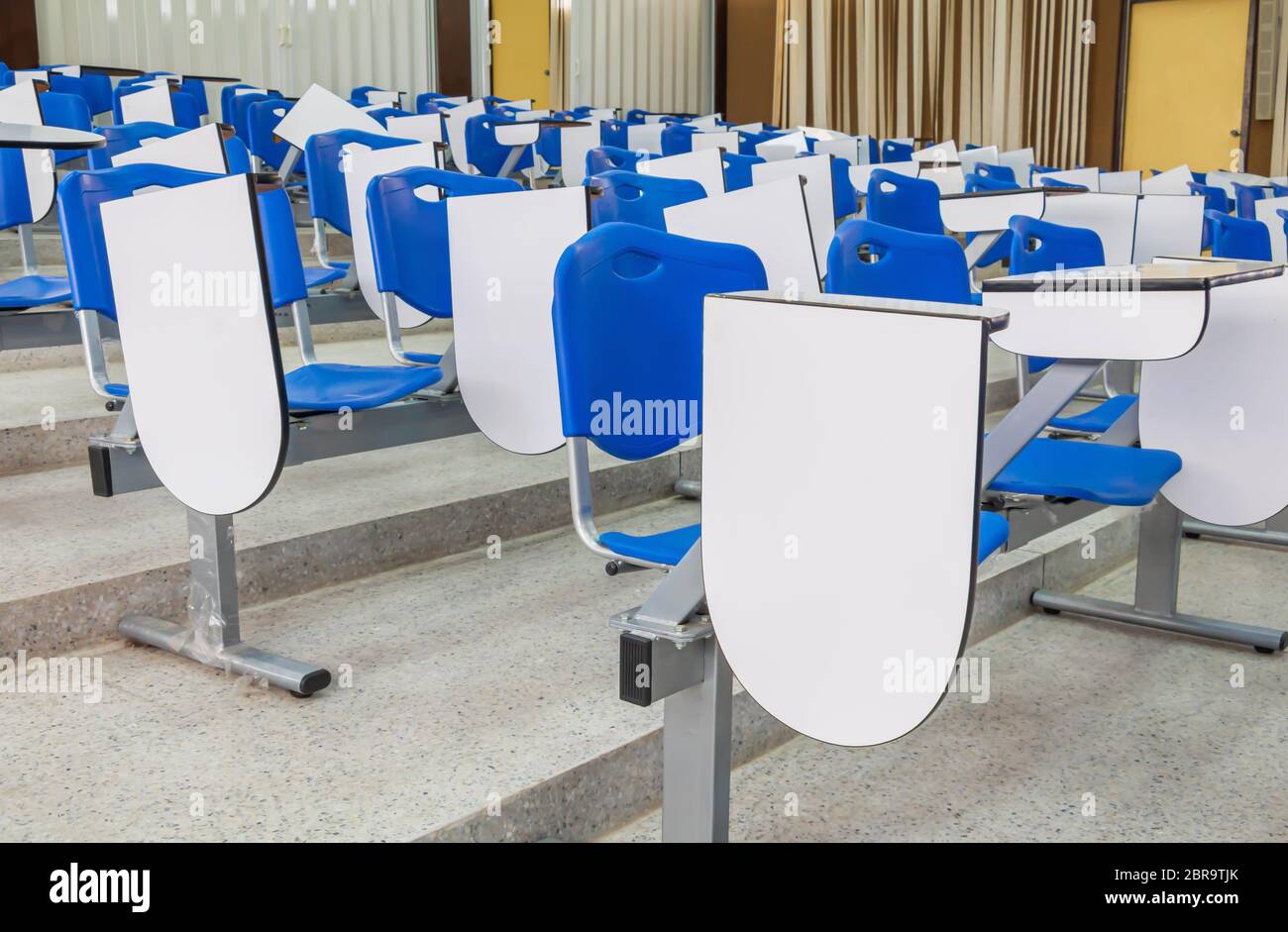 Sedia per conferenze a fila blu in plastica nella sala riunioni della classe al piano terra: Selezionate il focus con profondità di campo bassa Foto Stock
