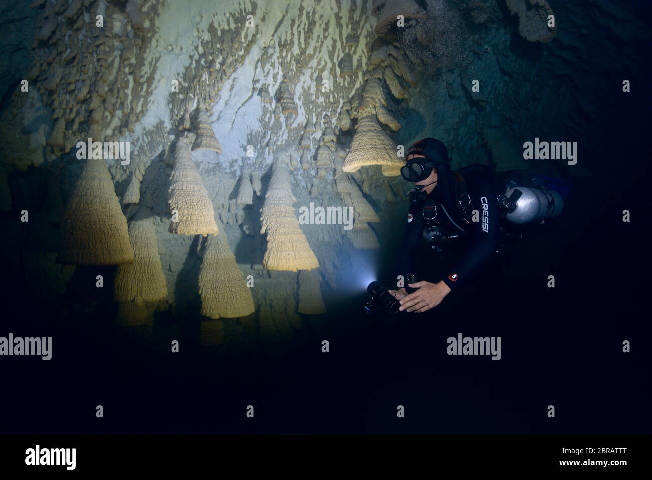 Il subacqueo tecnico sidemount nuota lungo il muro di Cenote Zapote, dolina con magiche formazioni calcaree di Hells Bells in Messico. Foto Stock