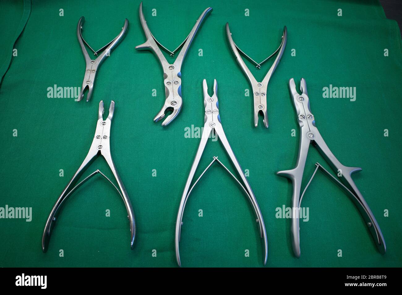 diverse pinze ossee chirurgiche si trovano fianco a fianco su un telo chirurgico Foto Stock