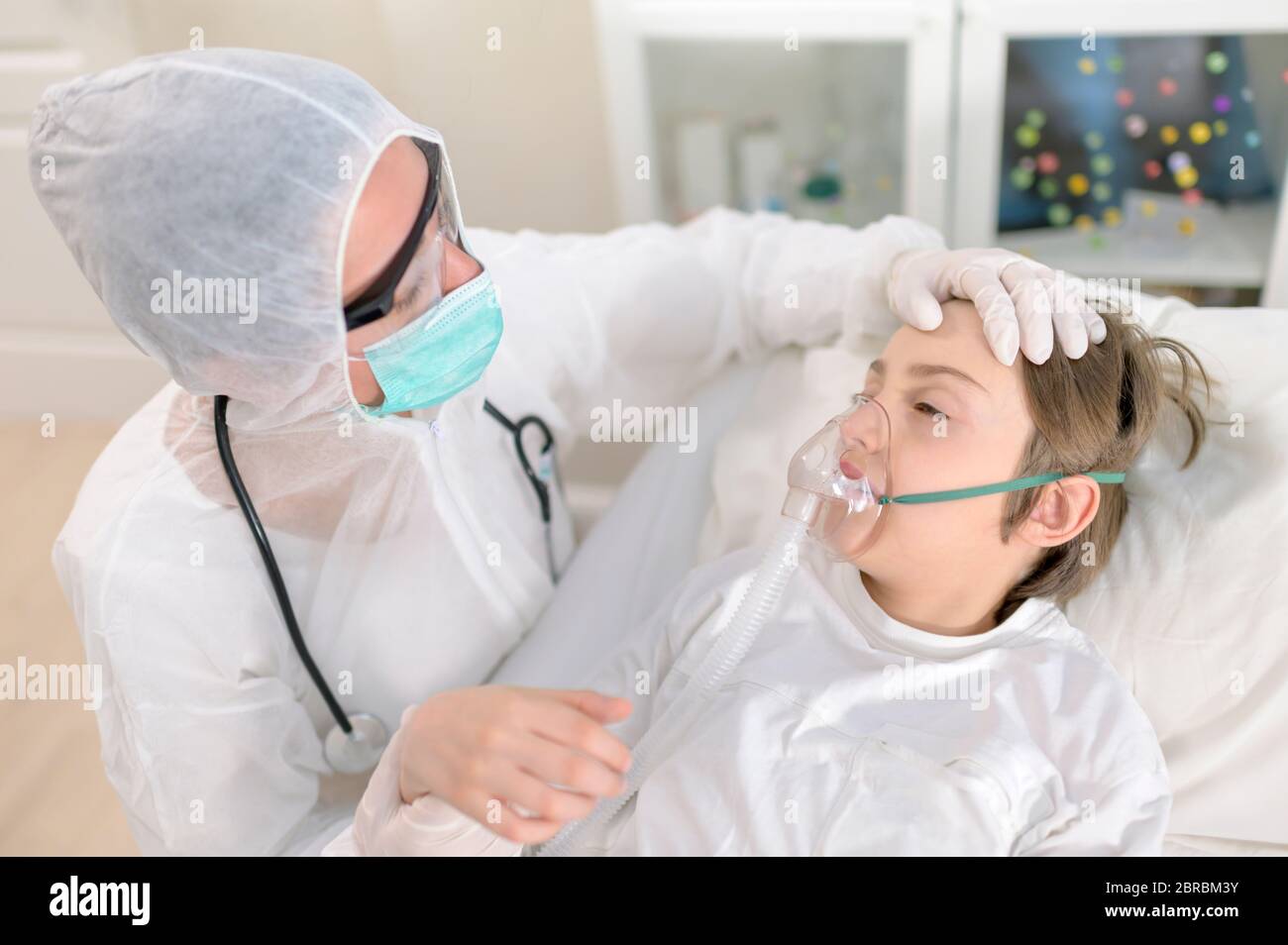 Empathic femmina medico tratta e intubare un bambino con virus respiratorio Foto Stock