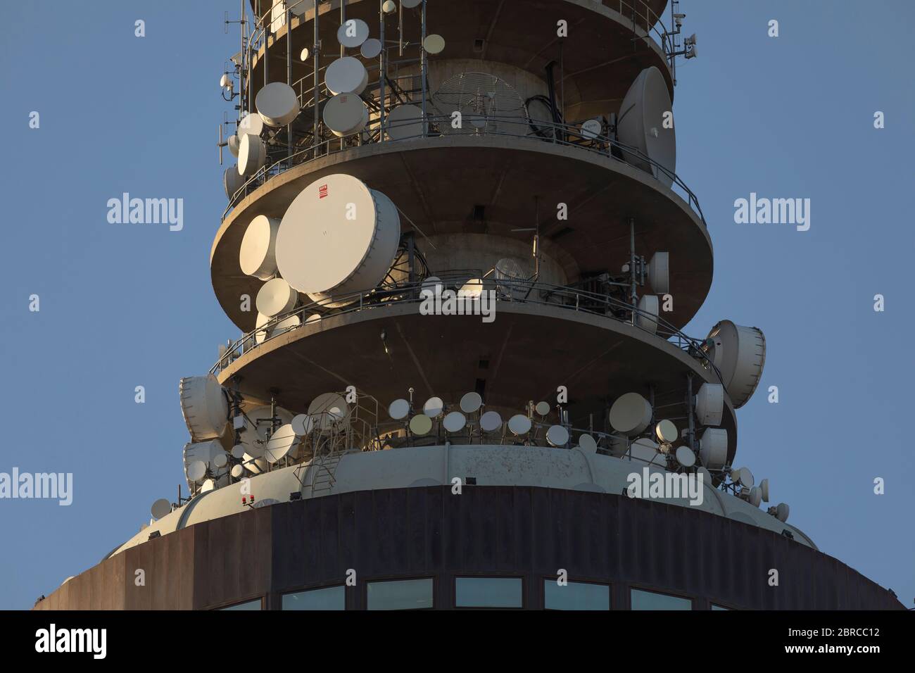 Madrid, Spagna - 19 maggio 2020: Primo piano della torre della televisione digitale e della radio Torrespaña al tramonto, con il suo sciame di piatti satellitari. Foto Stock