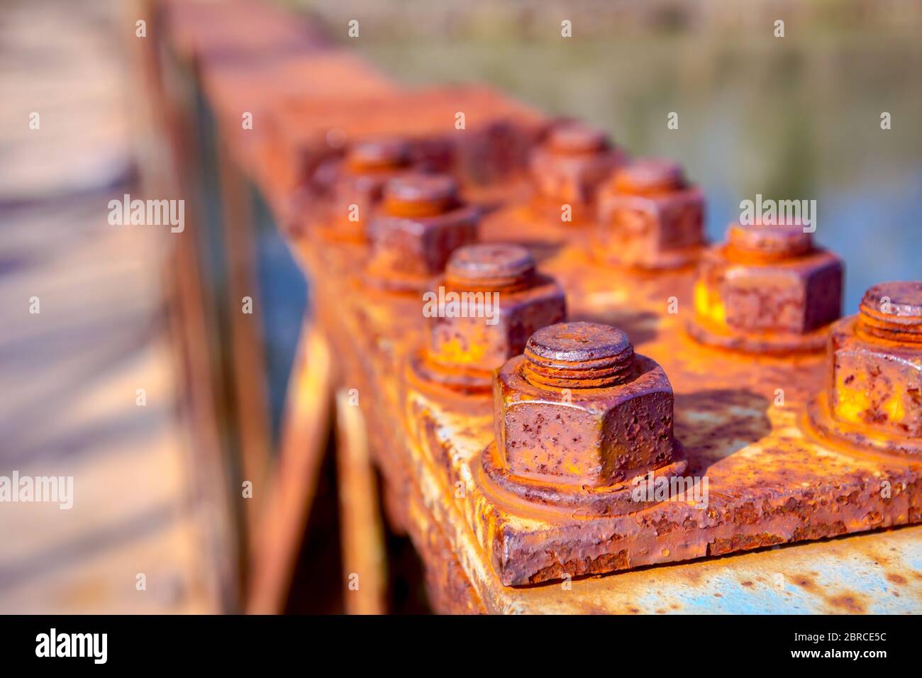 Particolare della costruzione in acciaio con vecchie viti arrugginite sulla recinzione del ponte. Foto Stock