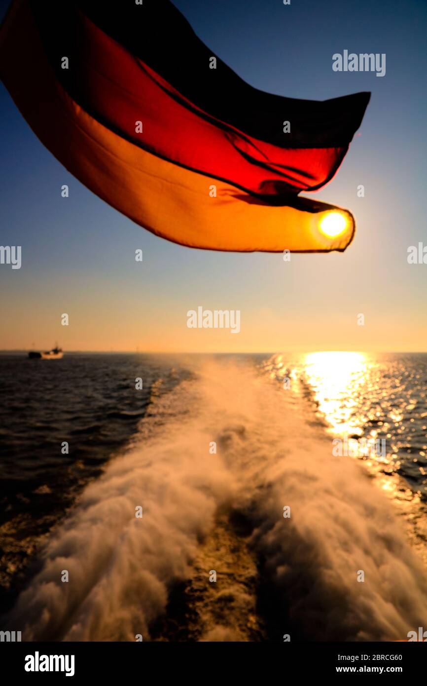 La bandiera della Germania su una nave al tramonto Foto Stock