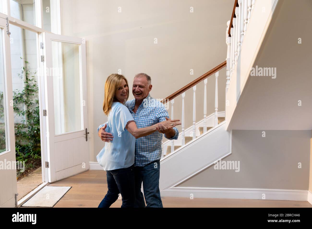 Coppia caucasica che danzano e sorridono nel corridoio Foto Stock