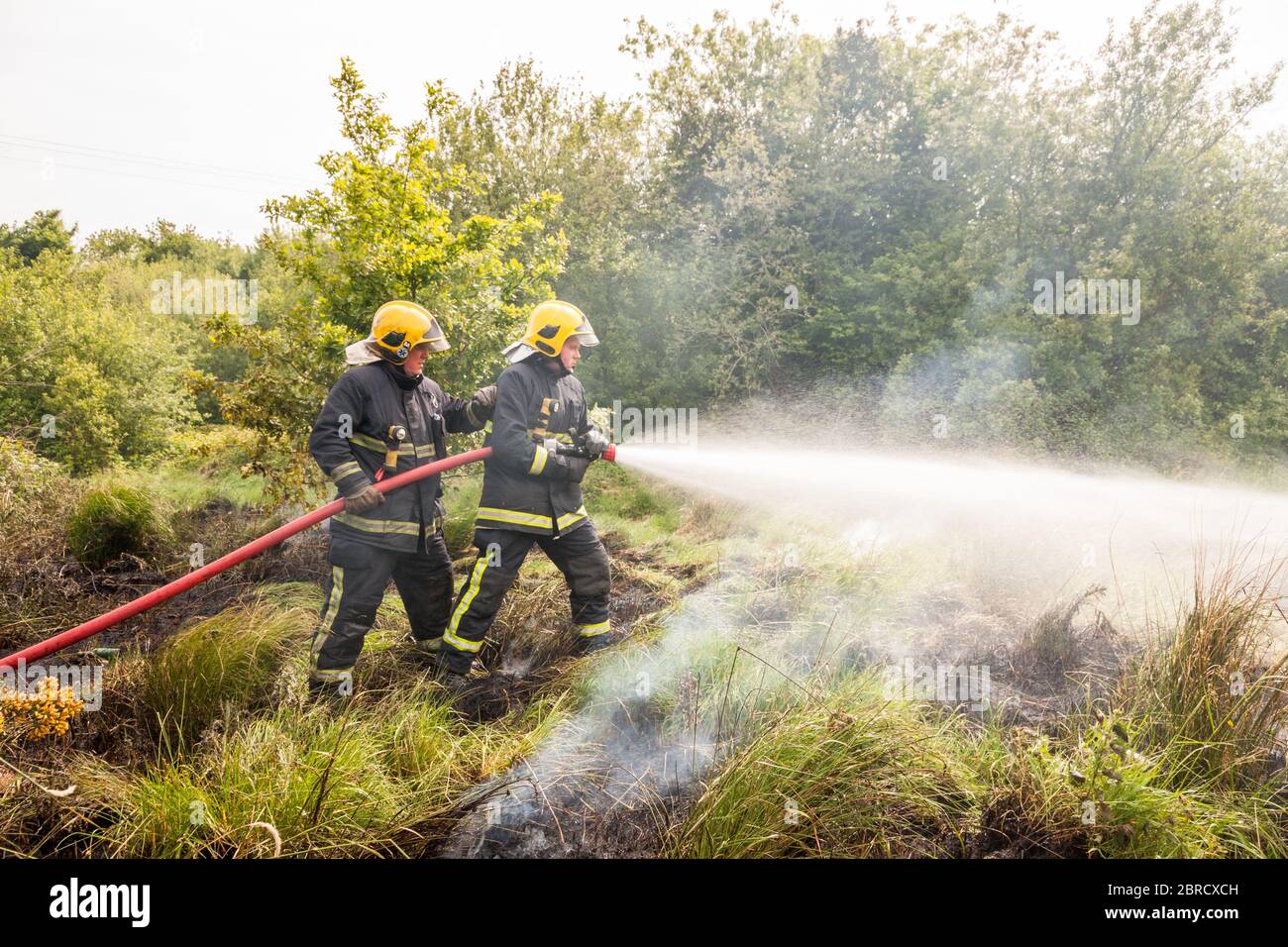 Carrigaline, Cork, Irlanda. 20 Maggio 2020. Due unità della brigata antincendio spengono un incendio di gola che si è svolto su un terreno di rifiuti fuori della città di Carrigaline, Co. Cork, Irlanda. - credito; David Creedon / Alamy Live News Foto Stock