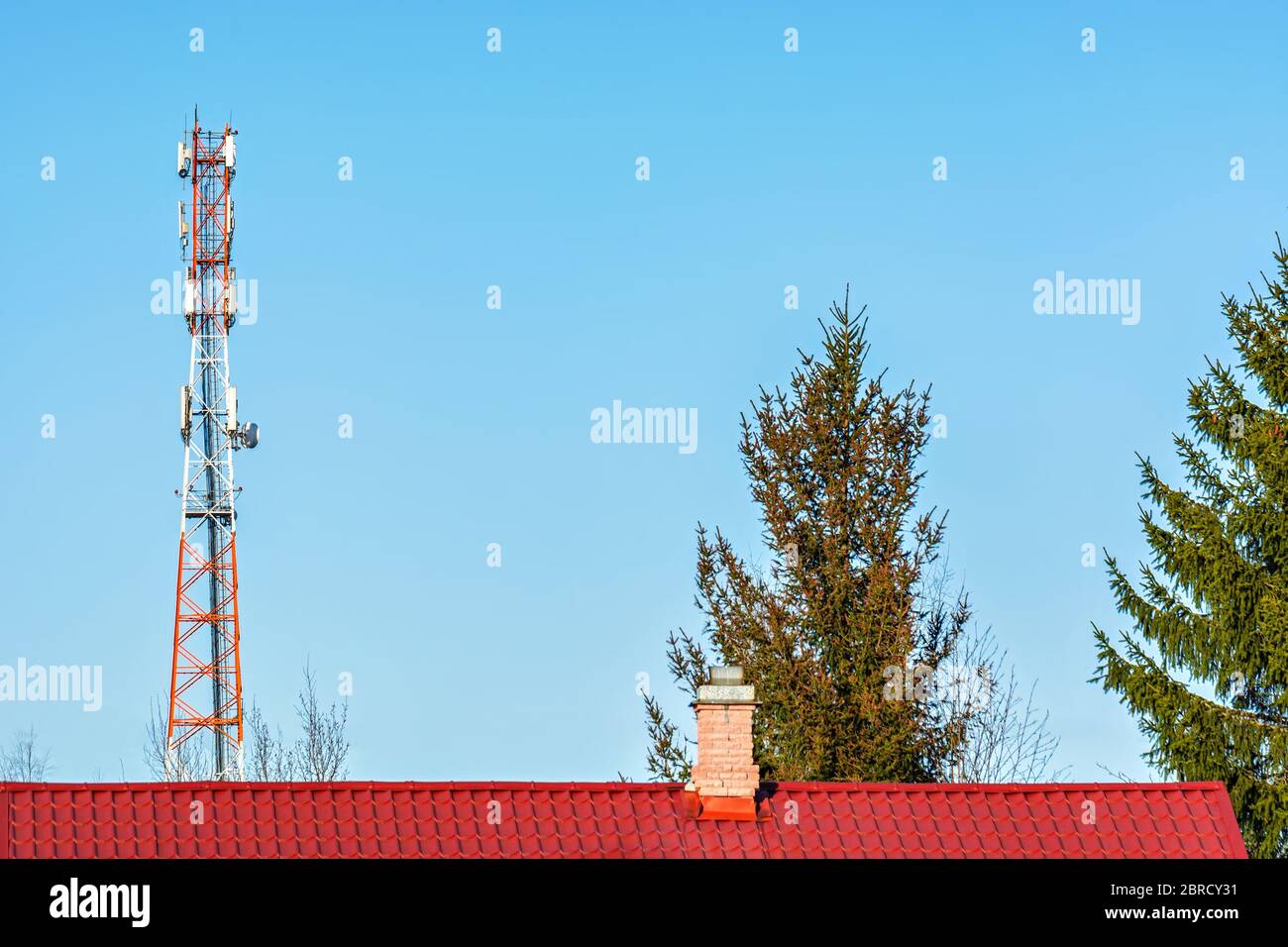 Torre cellulare su uno sfondo di cielo blu in una giornata di sole luminoso. Foto Stock