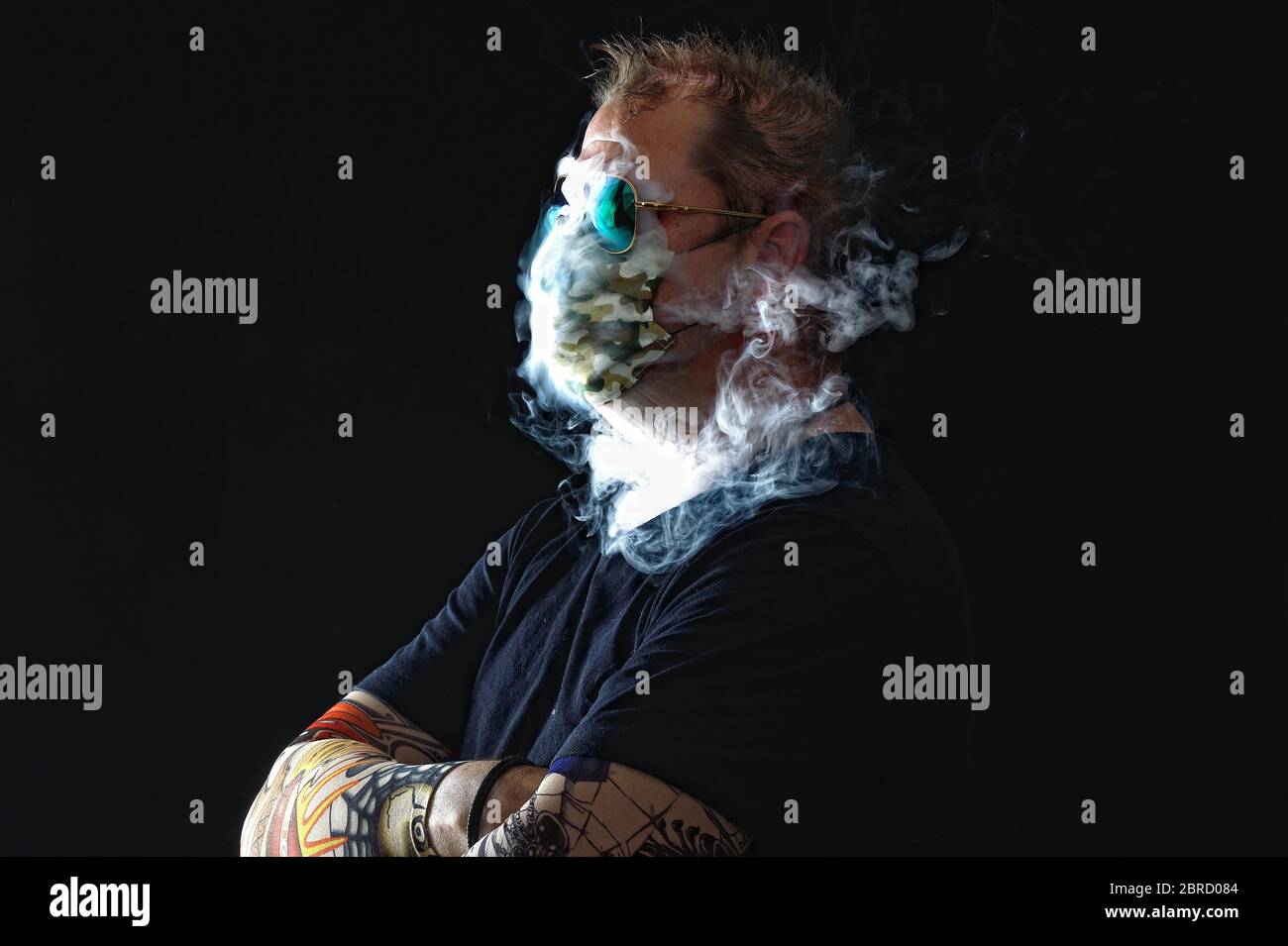 Uomo con maschera fumante sigaretta, serie Corona, Germania Foto Stock