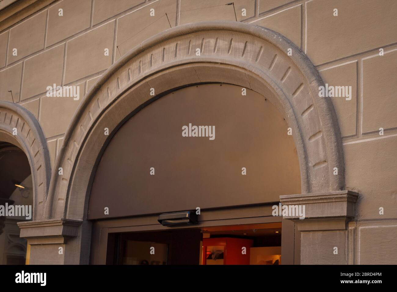 Costruzione con una vetrina. Piatto vuoto sotto forma di arco su una vecchia casa. Spazio vuoto per un numero, un testo o un nome di memorizzazione sul vetro. Vista laterale da Foto Stock