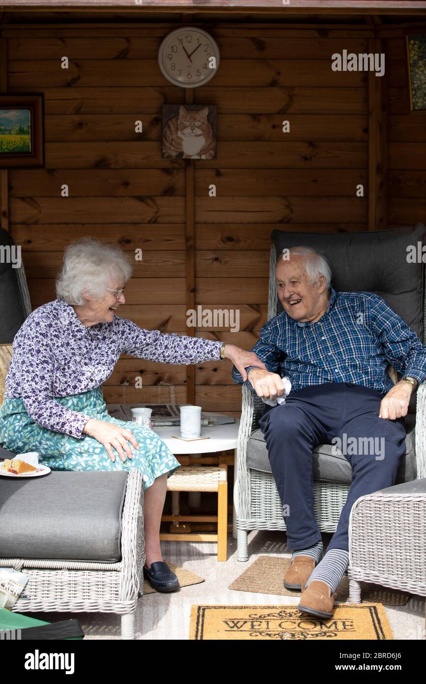 Le coppie anziane sposate negli anni 80 si divertono a sedere nella loro casa estiva durante i giorni più caldi dell'anno, Inghilterra, Regno Unito Foto Stock