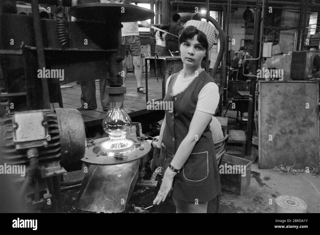 giovane lavoratrice operatrice di macchina mentre lavora in vetreria anni 70 saltotarjan ungheria Foto Stock