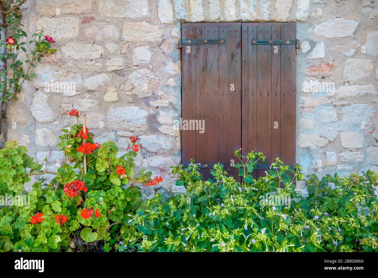 Persiane chiuse in legno sulla parete di pietra di un antico casale francese in un villaggio rurale in Provenza, Francia. Foto Stock