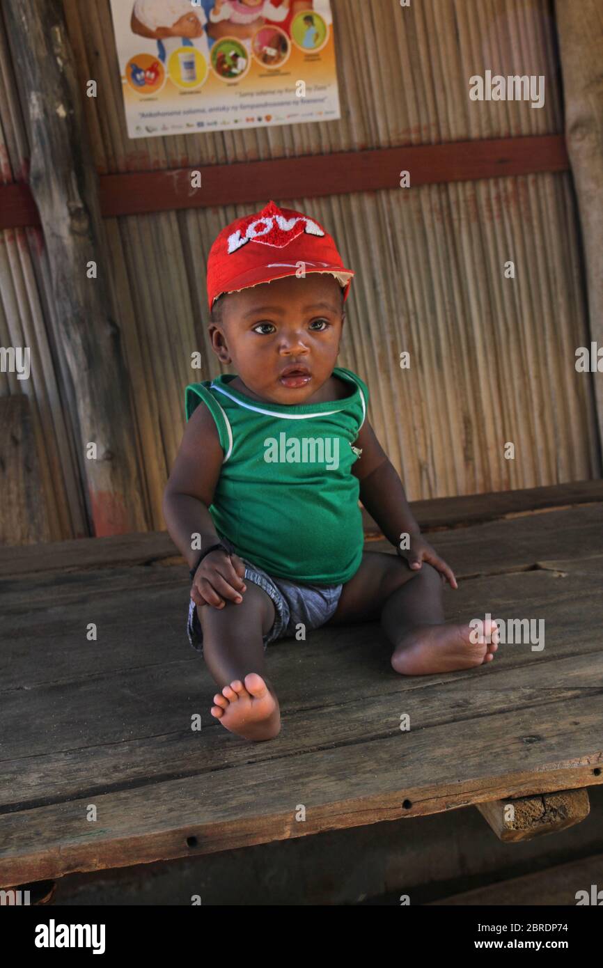 Bambino africano seduto al tavolo, Ampangorinana Village Nosy Komba Island, Madagascar. Foto Stock