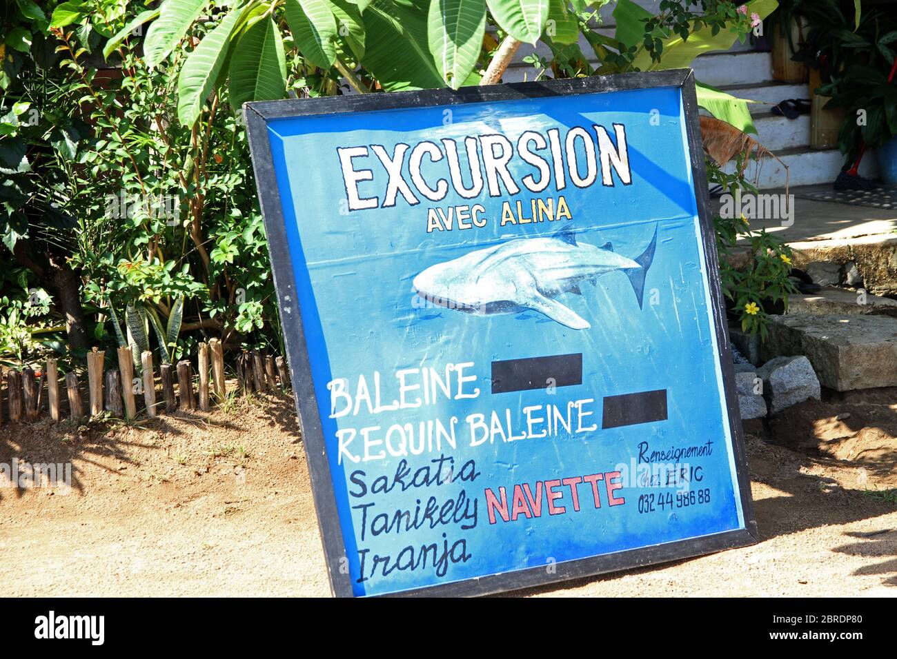 Avviso di cartello pubblicitario tour degli squali e lista dei nomi degli hotel nel villaggio di Ampangorinana Nosy Komba Island, Madagascar. Foto Stock