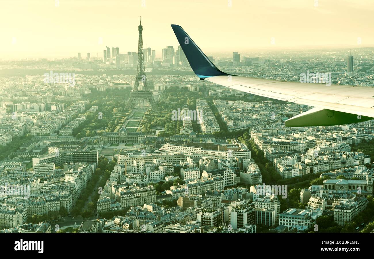 L'aereo vola sopra Parigi, Francia. Vista panoramica aerea della Torre Eiffel dalla finestra dell'aereo. L'ala dell'aereo sulle strade di Parigi. Concetto di TR aria Foto Stock