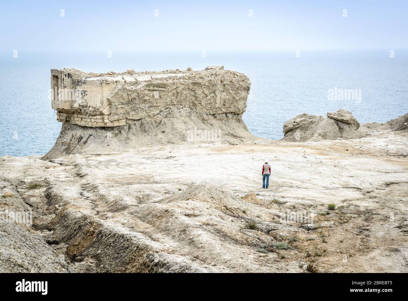 Scavate fortificazioni dalla seconda guerra mondiale a Feodosia, Crimea, Russia. Il viaggiatore cammina tra le rovine sulla costa deserta della Crimea. Il post Foto Stock