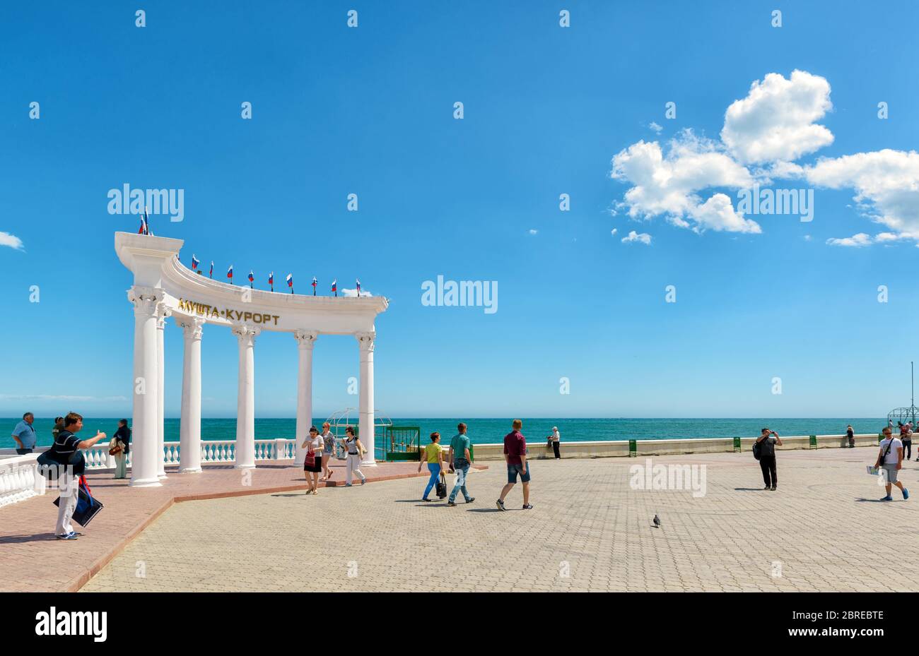 ALUSHTA, RUSSIA - 15 MAGGIO 2016: I turisti camminano lungo la passeggiata nella città di Alushta in Crimea. Il Rotunda 'Resort Alushta'. Foto Stock