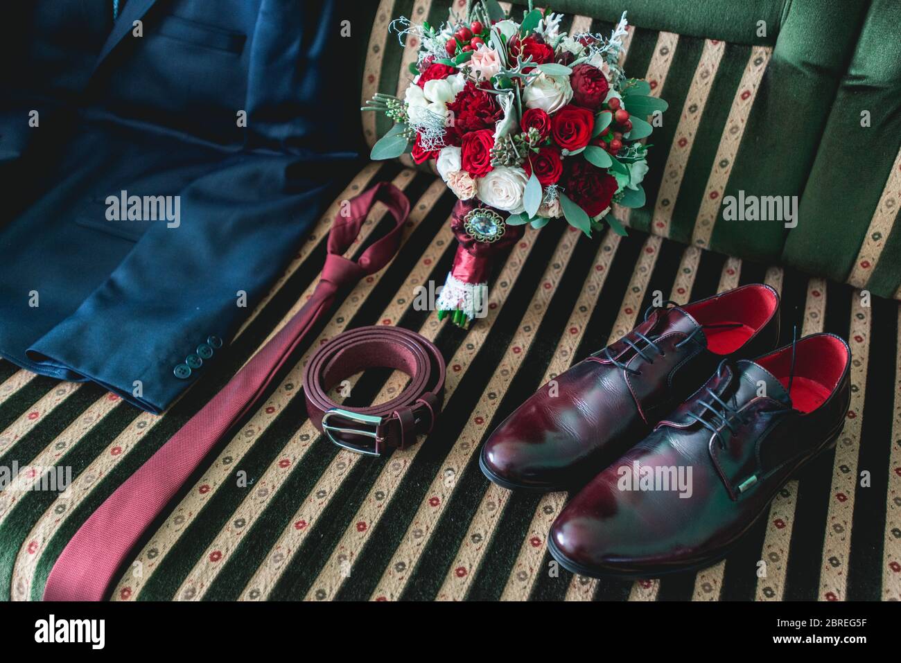 cintura, colletto, abito, scarpe e bouquet da sposa su un divano vintage Foto Stock