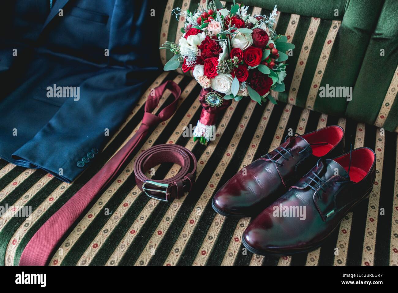 cintura, colletto, abito, scarpe e bouquet da sposa su un divano vintage Foto Stock