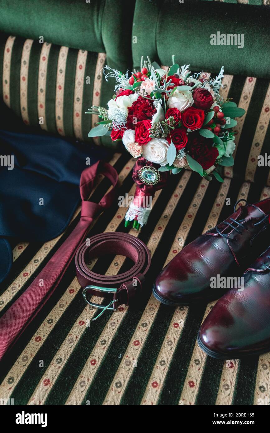 cintura, colletto, abito, scarpe e bouquet da sposa su un divano vintage Foto Stock