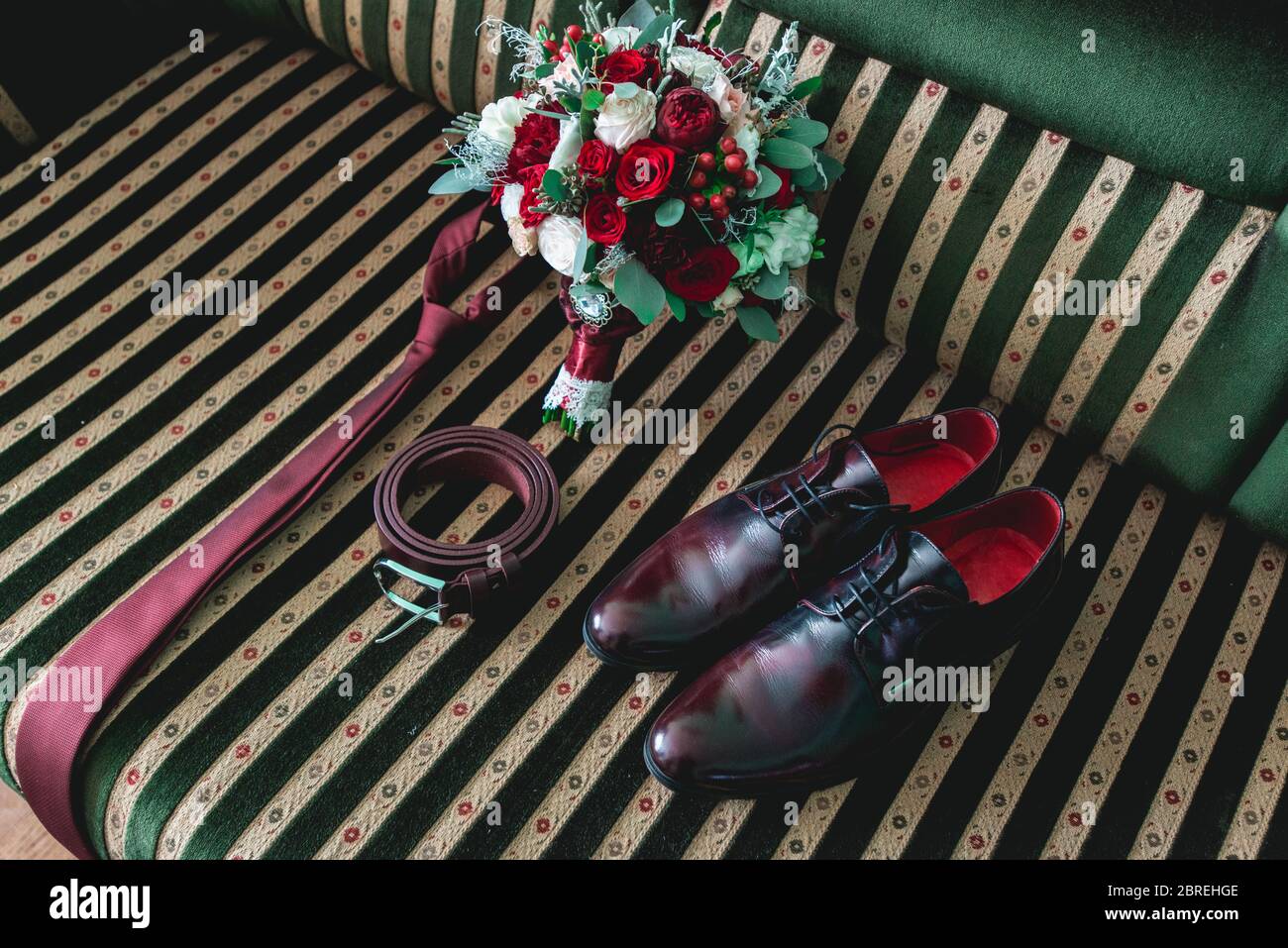 cintura, colletto, abito, scarpe e bouquet da sposa su un divano vintage Foto Stock