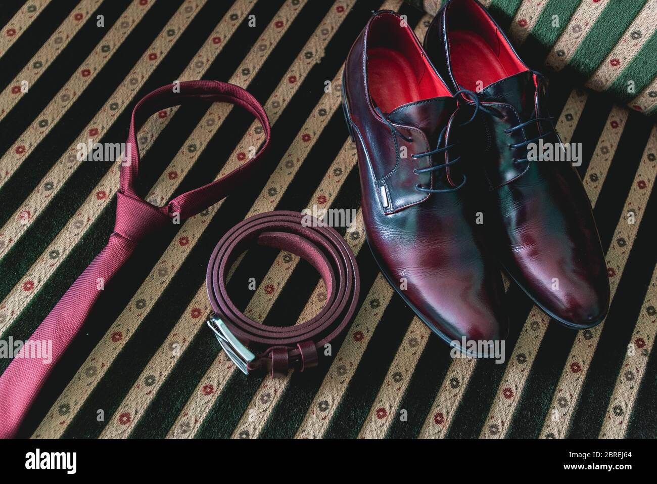 cintura, cravatta e scarpe su un divano vintage Foto Stock