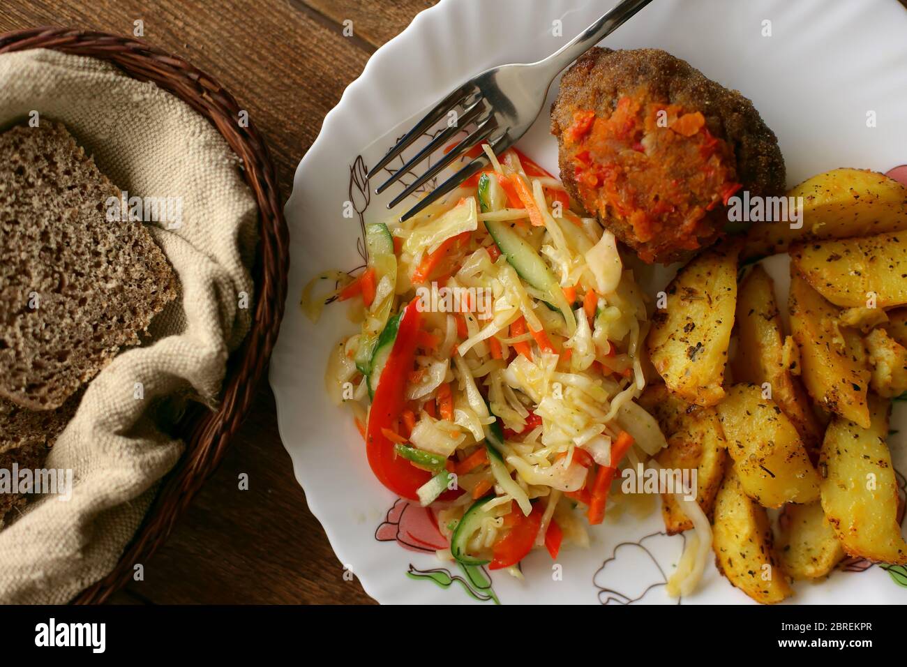 Cibo su un piatto. Semplice pranzo fatto in casa: Patate fritte, polpette e una porzione di insalata. Nutrizione sociale. Vista dall'alto Foto Stock