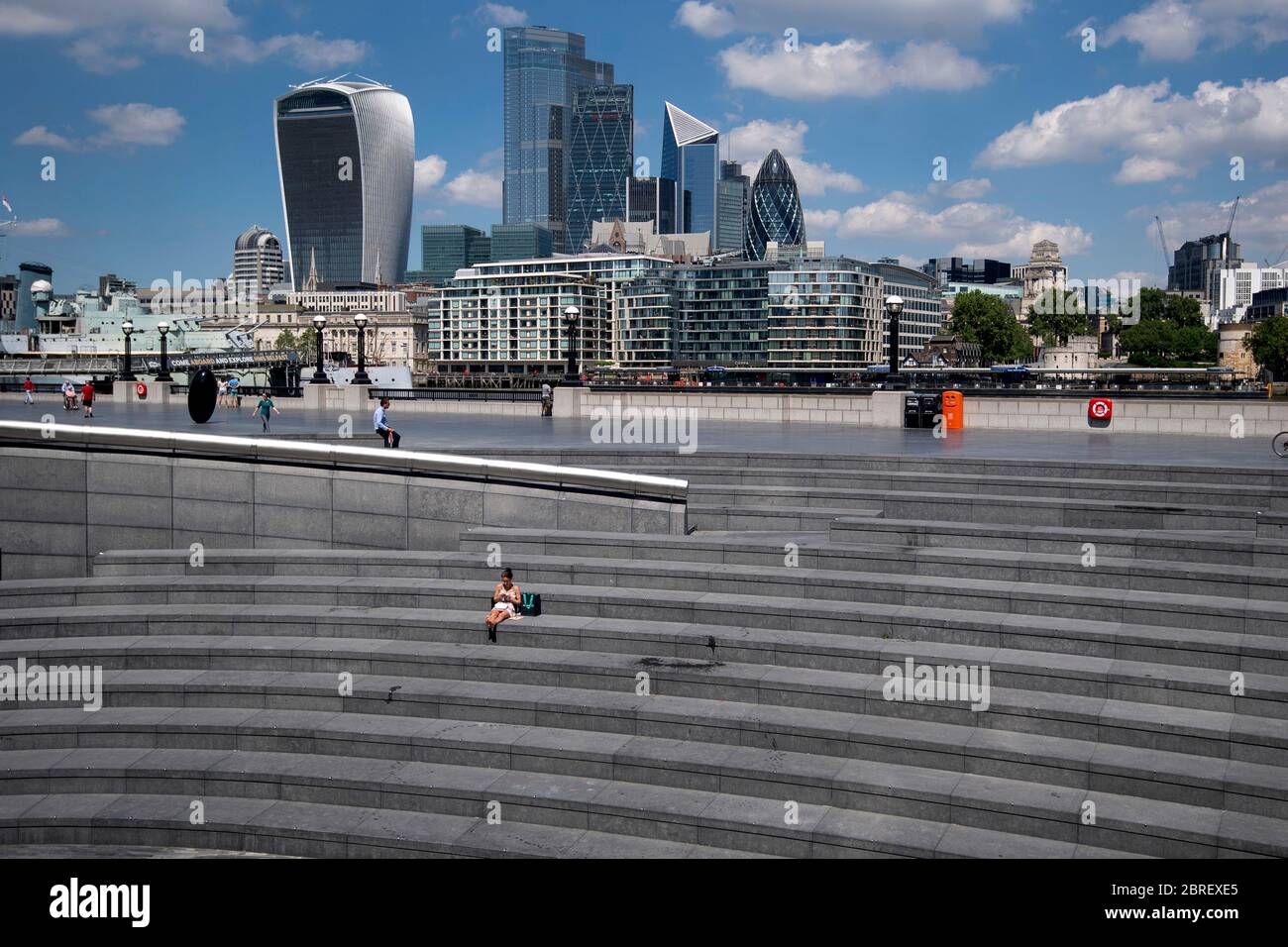 Una donna solitaria si siede in più Londra durante quello che normalmente sarebbe il pranzo occupato periodo come la gente si affollano a parchi e spiagge con misure di blocco attenuato. Foto Stock