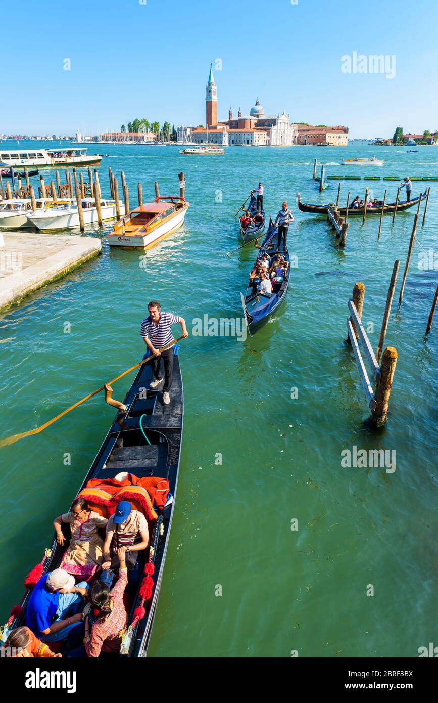 Venezia, Italia - 18 maggio 2017: Le gondole con i turisti navigano lungo un canale. La gondola è il mezzo di trasporto turistico più attraente di Venezia. Foto Stock