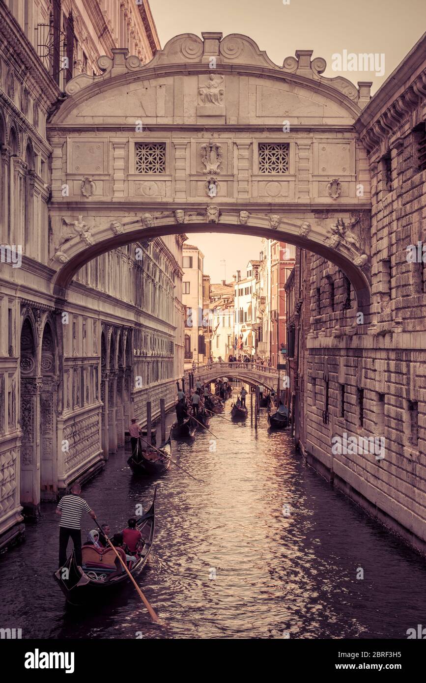 Venezia, Italia - 18 maggio 2017: Le gondole con i turisti navigano lungo lo stretto canale sotto il famoso Ponte dei Sospiri presso il Palazzo Ducale di`s. La gondola Foto Stock