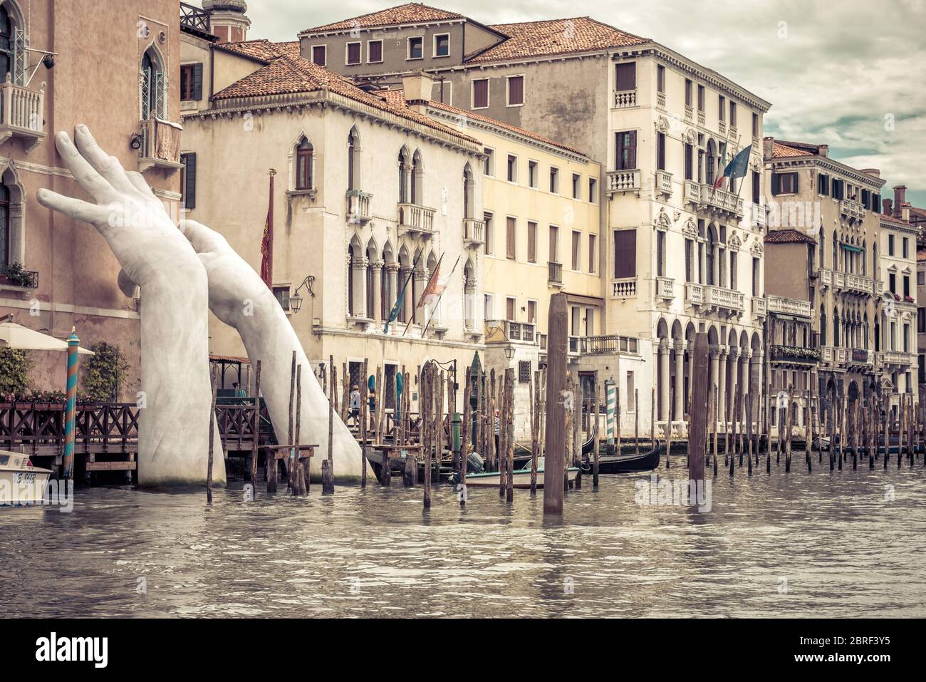 Venezia, Italia - 21 maggio 2017: Le mani giganti si alzano dall'acqua del Canal Grande per sostenere l'edificio. Questa potente relazione sul cambiamento climatico Foto Stock