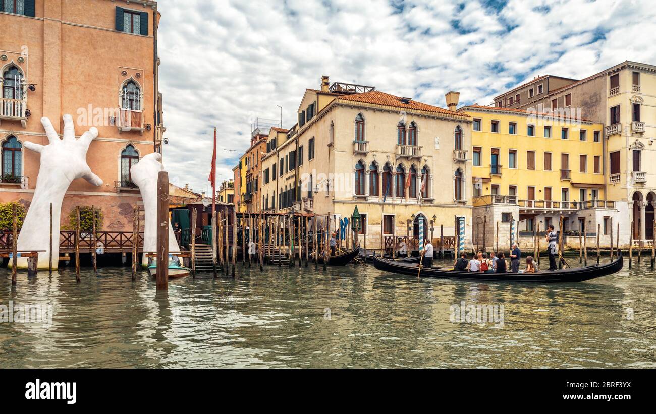 Venezia, Italia - 21 maggio 2017: Le mani giganti si alzano dall'acqua del Canal Grande per sostenere l'edificio. Questa potente relazione sul cambiamento climatico Foto Stock